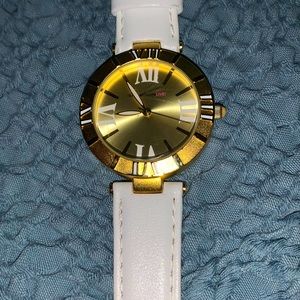 Isaac mix rah white leather band with a gold tone face watch.